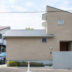 高田のコートハウス　外観　東側の前面道路から見る　南に駐車スペースなどの外部空間をまとめ北に建物を寄せている