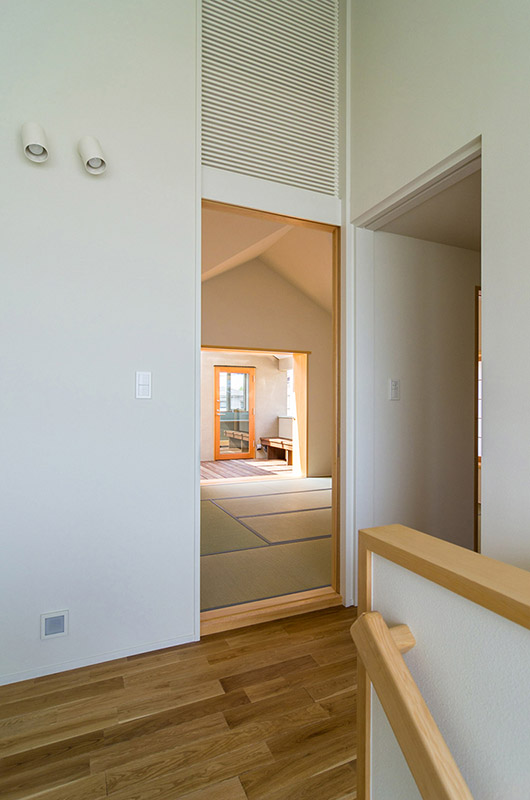 浦和の２つの家　姉の家　和室からカバードデッキ、離れの彫金室を見通す　入口上の格子はパッシブソーラーシステムの空気の経路