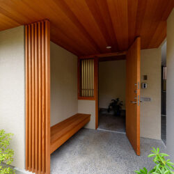 三島の家　ポーチから玄関を見る　玄関扉の横は換気のための窓で格子網戸を室内側に設けている